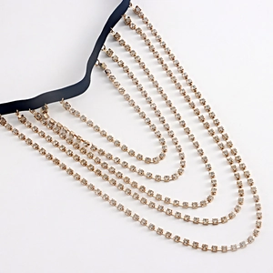 Close-up of sexy multi-layer gold leg chain with rhinestones on black elastic band