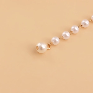 Close-up of double-layer faux pearl waist chain with golden metal clasp and fine craftsmanship