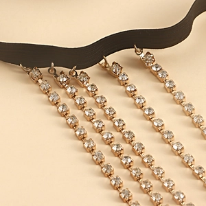 Detail of crystal rhinestone fringe leg chain with gold-plated rings and black elastic band