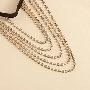 Macro detail of sexy gold multi-layer rhinestone thigh chain with black elastic strap