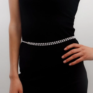 Elegant double-layered faux pearl waist chain with golden metal links on black dress