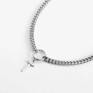 Detail shot of silver Cuban chain choker with a circular ring and cross sword pendant