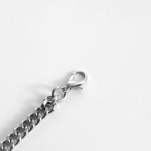 Detailed close-up of a silver stainless steel chain necklace with a lobster clasp closure