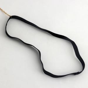 Détail de la bande de jambe élastique noire avec chaîne dorée pour un style sexy
