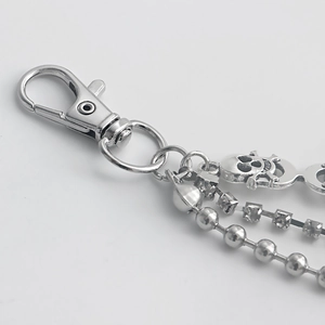 Detailed close-up of a silver skull shoe chain with rhinestones and bead layers