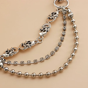 Detailed macro view of triple-layered silver metal shoe chain with skull and rhinestones