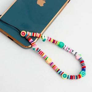 Colorful beaded phone charm with fruit shapes and LOVE letters on green smartphone