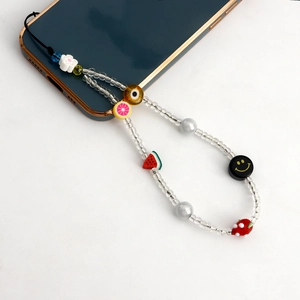 Détail du cordon de téléphone perlé avec motifs de fruits colorés et sourires sur mobile