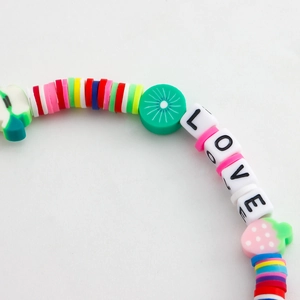 Macro shot of colorful handmade beaded phone strap with fruit charms and LOVE letters