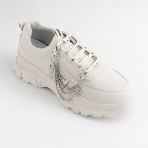 Zapatillas chunky crema con dijes de estrella plateados y cadenas metálicas decorativas
