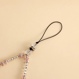 Detail of pink crystal beads and clear rice beads with rhinestone accents on phone charm