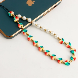 Handmade phone strap with colorful heart beads and faux pearls on a green smartphone
