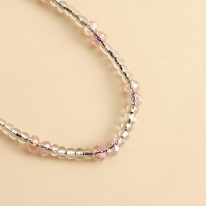 Macro detail of pink crystal beads and transparent beads with silver tubes on a phone charm