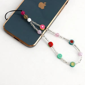 Détail du bijou de téléphone perlé fait main avec breloques de fruits colorés et perles