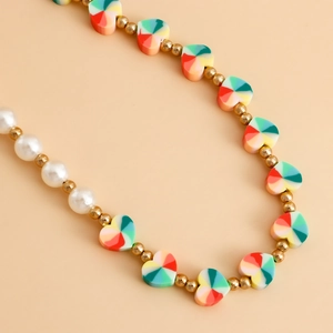 Macro shot of colorful heart-shaped beads and glossy white pearls on a vibrant phone lanyard