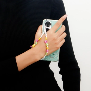 Detailed view of handmade beaded phone strap with colorful flowers on a green case
