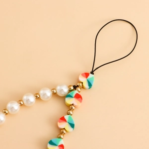 Macro detail of handmade colorful heart charms and imitation pearls on a phone lanyard