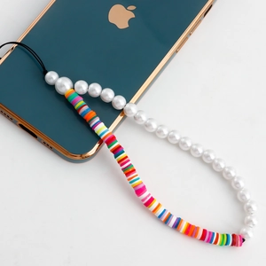 Vue détaillée du bijou de téléphone artisanal avec perles blanches et argile colorée