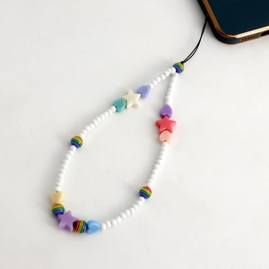 Détail de la dragonne de téléphone avec perles blanches et breloques en forme d'étoile