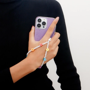 Handmade beaded phone strap with white pearls and colorful flower accents on a wrist