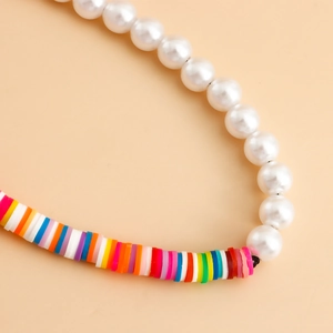 Détail de perles Heishi colorées faites à la main associées à des perles blanches polies