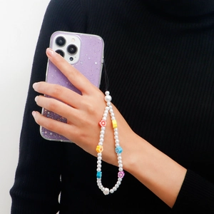 Detail of handmade beaded phone strap with white pearls and colorful flower beads