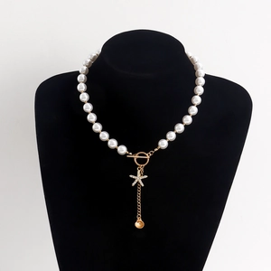 Detail of beaded pearl necklace with gold OT clasp, starfish charm and shell pendant