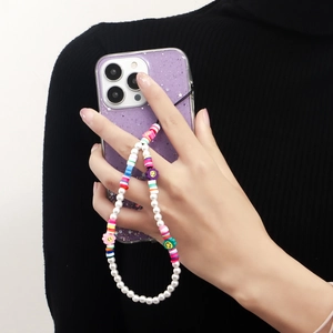 Detail of colorful beaded phone strap with pearls and smile flowers on a purple case