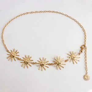 Detail of gold metal chain belt featuring sun face charms and lobster clasp closure