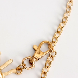 Detailed close-up of golden metal waist chain with a lobster clasp for dresses