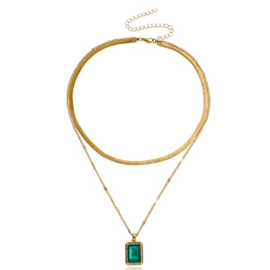 Double-layered gold snake chain necklace with emerald green gemstone pendant and crystal halo