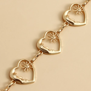 Golden heart belt chain featuring vintage celestial sun and moon faces on a warm background