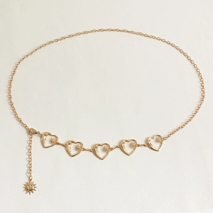 Detail of gold heart link waist chain with celestial sun motifs and textured moon charms