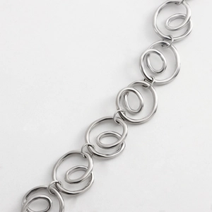 Macro shot of silver spiral geometric metal links showing polished craftsmanship on waist chain