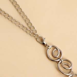 Macro detail of silver spiral metal rings and lobster clasp on this minimalist waist chain