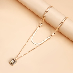 Detailed close-up of double-layer gold snake chain necklace with champagne gemstone pendant