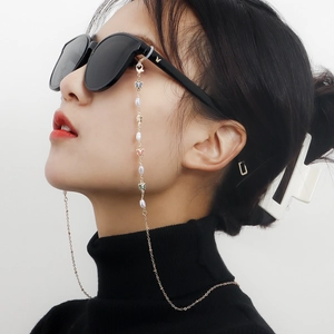Goldene Brillenlkette mit weißen Perlen und Emaille-Schmetterlingen auf der Sonnenbrille