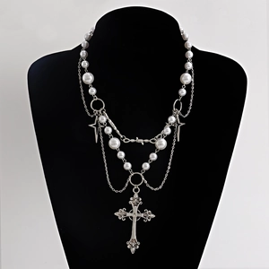 Detail of gothic multi-layer pearl necklace with silver star and hollow cross pendants