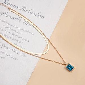Detail of double-layer snake chain with blue gemstone pendant and micro-inlaid rhinestones