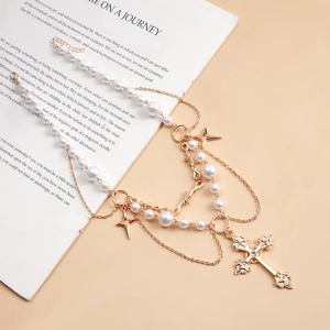 Macro view of double-layer necklace with pearl strands and cross star metal pendants