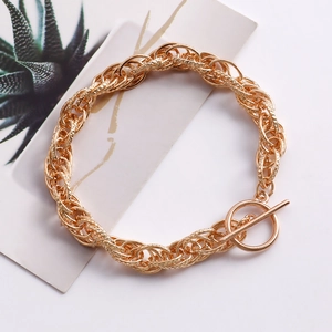 Detail eines goldenen Gliederkettenarmbands mit OT-Verschluss auf dezentem Hintergrund