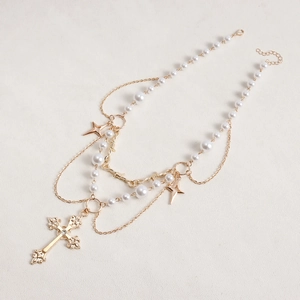 Detailed close-up of double-layer necklace with high-gloss pearls and gothic cross pendant