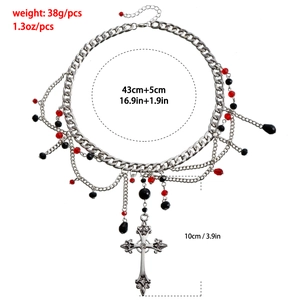 Detailed view of Gothic multi-layer cross necklace with red beads and chain tassels