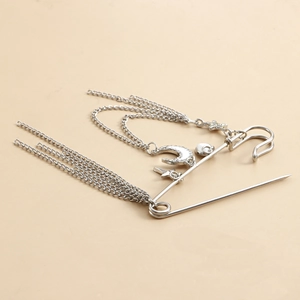 Détail de la broche épingle à nourrice argentée avec pendentif lune et longues chaînes