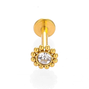 Détail d'un piercing de lèvre en acier 316L doré avec une fleur en zircone