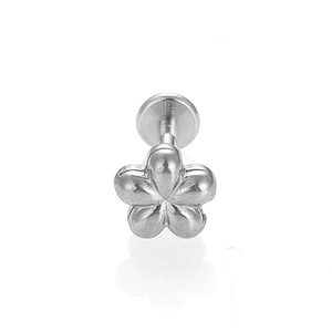 Vista macro de un piercing labret de flor en acero inoxidable plateado con diseño plano