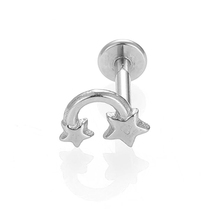 Detalle macro del piercing labret de acero plateado con diseño de meteoro de doble estrella