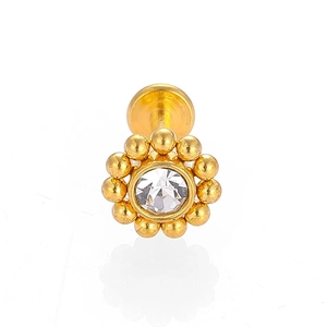 Détail macro d'un piercing fleur dorée avec zircon clair et finition à dos plat lisse