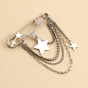 Détail d'une broche étoile argentée avec chaînes multicouches et strass brillants