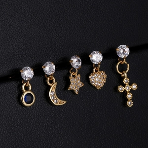 Detailed macro view of five gold zircon stud earrings with celestial and heart pendants